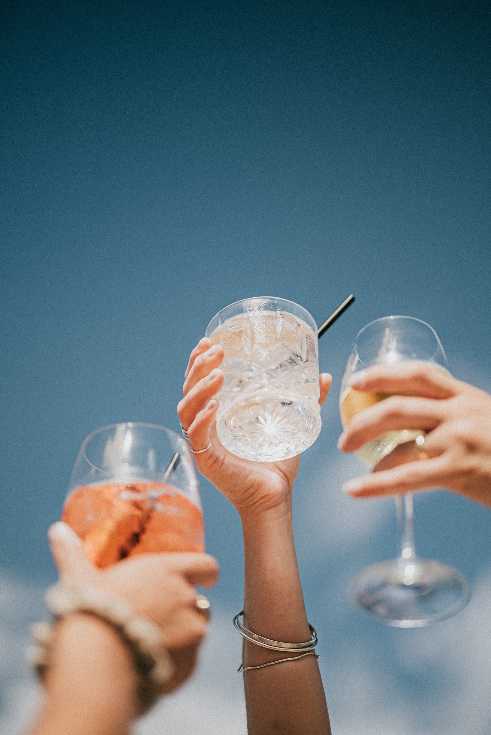 Three people holding glasses of different drinks